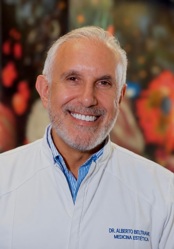 Dr. Alberto Beltrame, médico responsável pela Clínica Beltrame, sorrindo, de jaleco branco