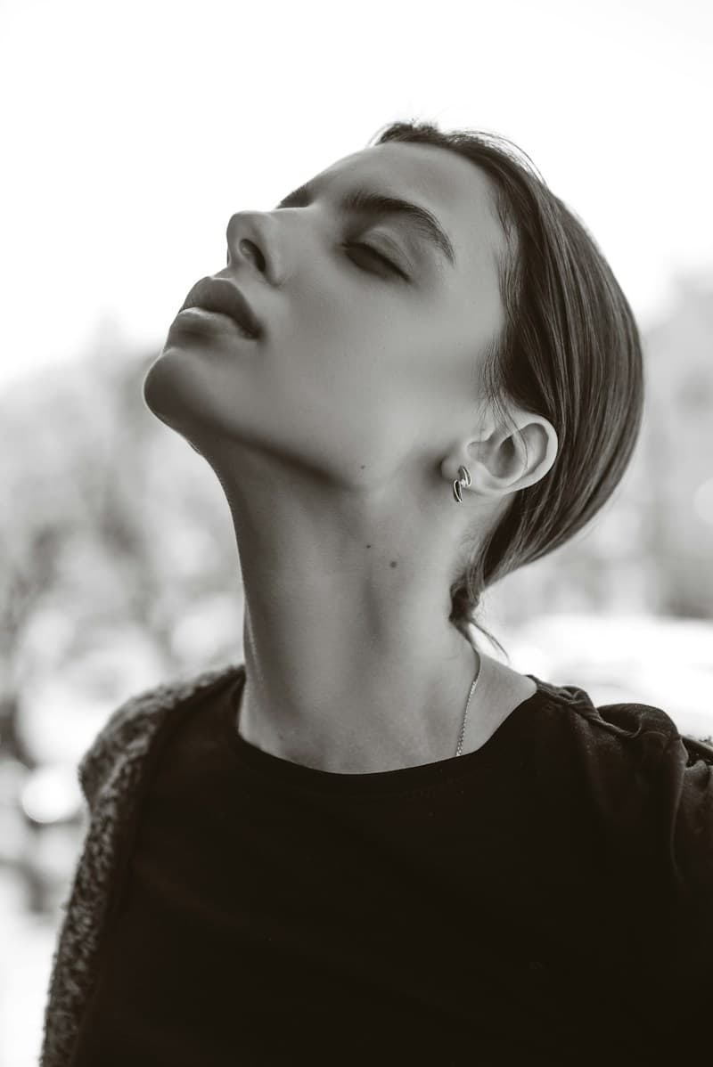 Perfil de mulher com o queixo erguido em preto e branco